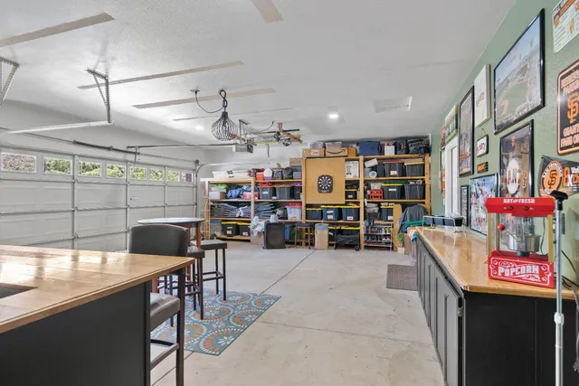 a kitchen with stainless steel appliances granite countertop a table chairs sink and cabinets