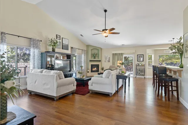 a living room with furniture chandelier and a wooden floor