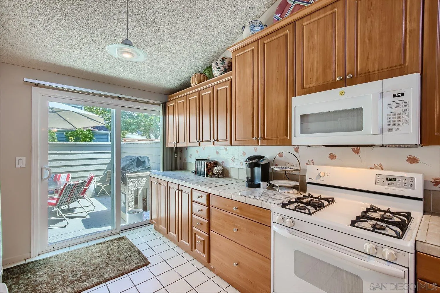 1812 Wilton Road Encinitas, CA 92024 - Photo 16 of 26 a kitchen with stainless steel appliances a stove a sink cabinets and a window
