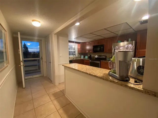a kitchen with stainless steel appliances granite countertop a stove microwave and cabinets