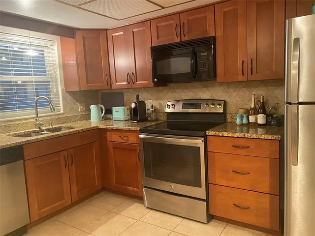 a bathroom with a granite countertop sink a toilet and a mirror