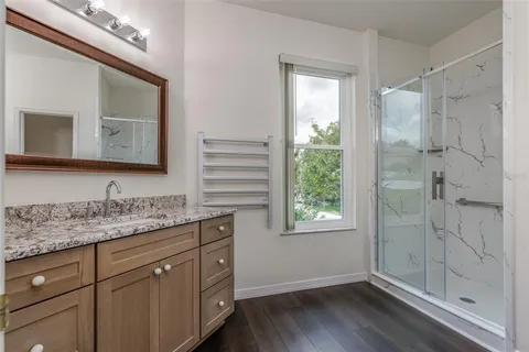 a bathroom with a granite countertop sink toilet and shower
