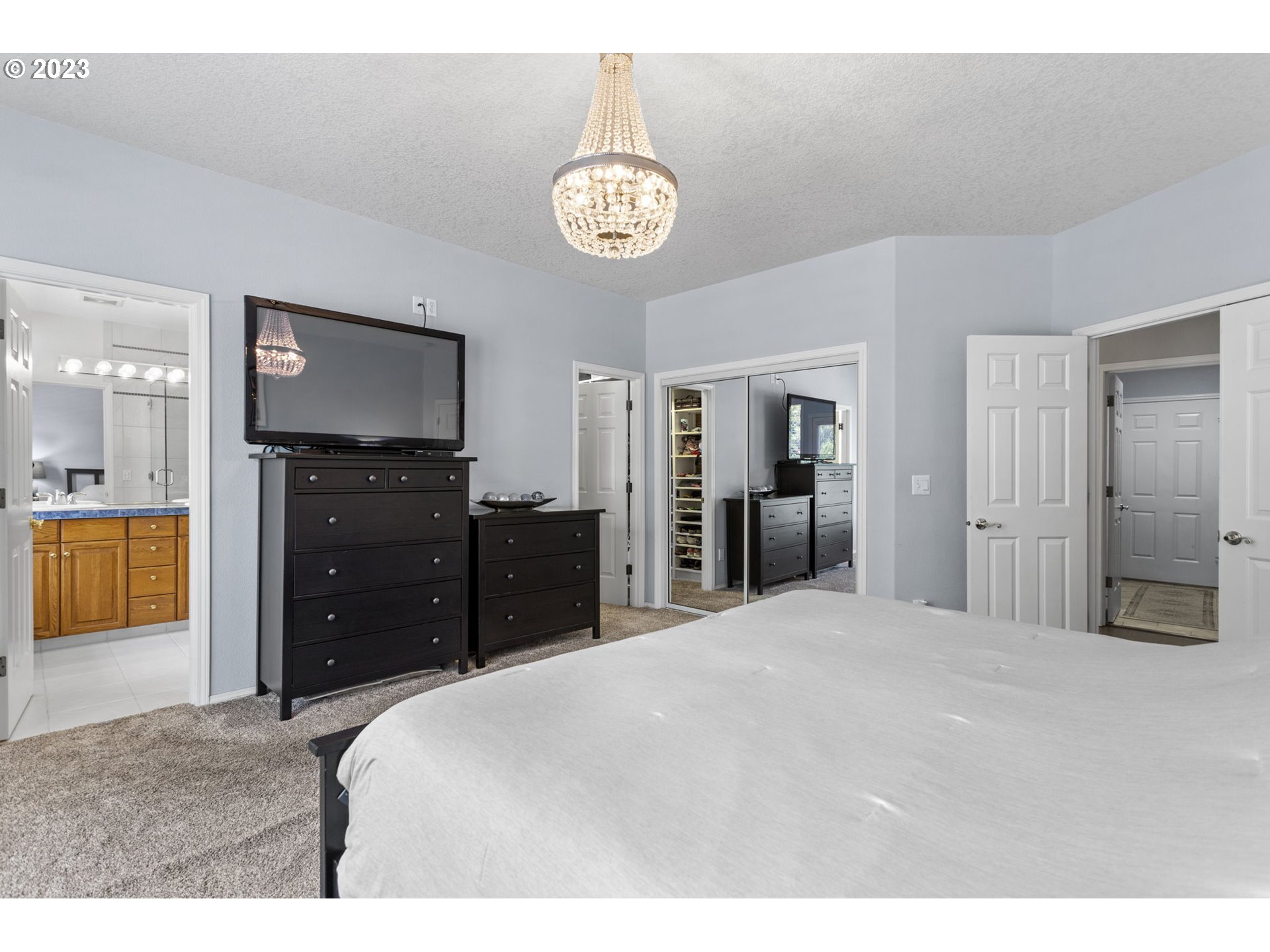 3064 South 23rd Way Ridgefield, WA 98642 - Photo 20 of 29 a large bedroom with a large bed and chandelier
