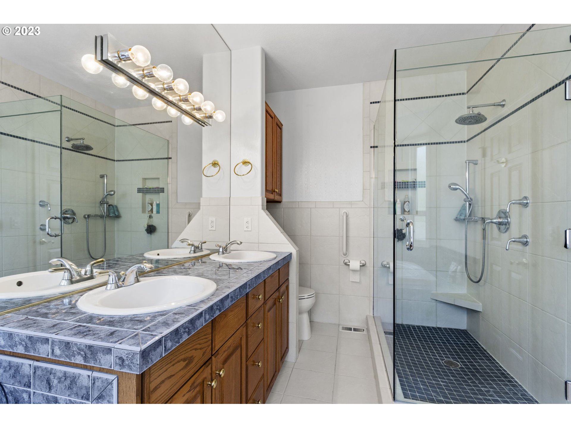 3064 South 23rd Way Ridgefield, WA 98642 - Photo 23 of 29 a bathroom with a granite countertop sink a mirror and a shower