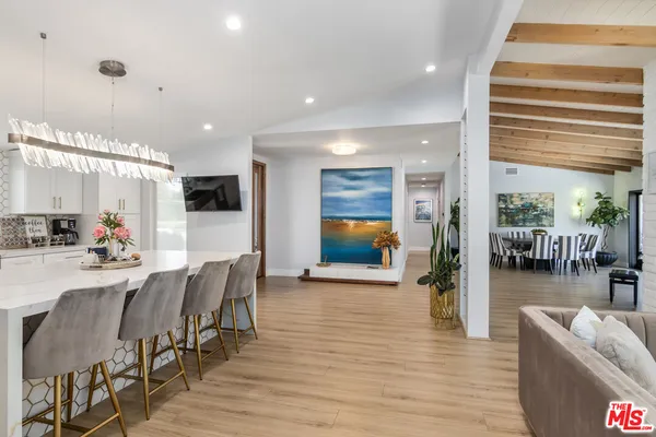 a living room with furniture floor to ceiling window and wooden floor