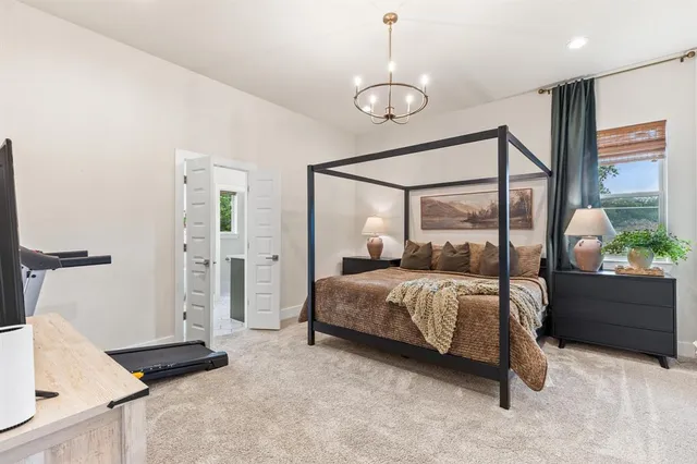 a bedroom with a bed and a chandelier