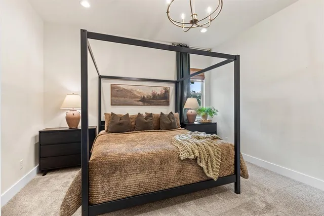 a bedroom with a bed a mirror and a potted plant