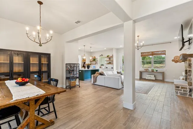 a living room with furniture kitchen view and a wooden floor