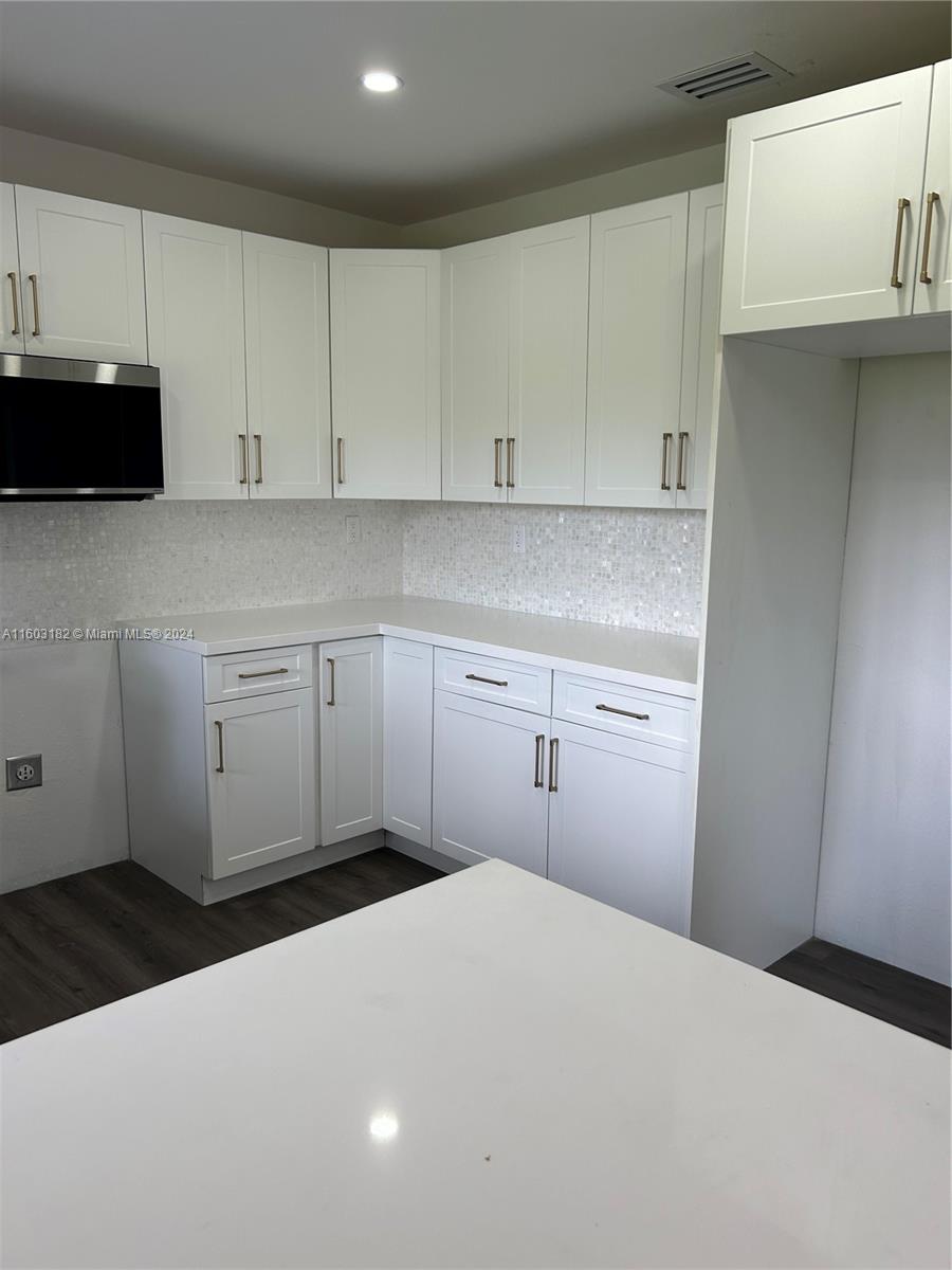 Westchester Miami, FL 33165 - Photo 4 of 14 a kitchen with a stove and white cabinets