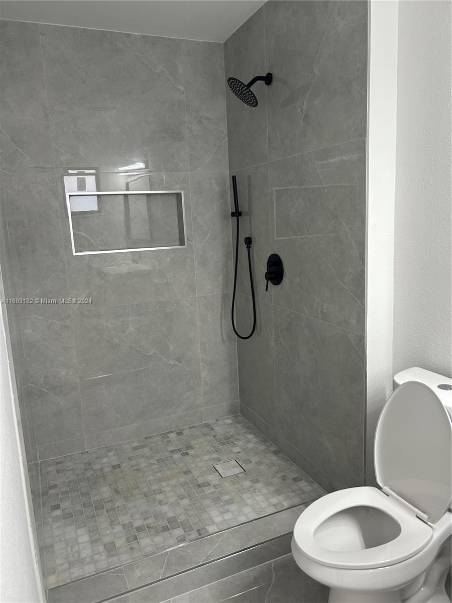 Westchester Miami, FL 33165 - Photo 5 of 14 a white toilet sitting next to a bath tub and shower