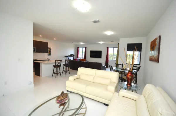 a living room with furniture and kitchen view