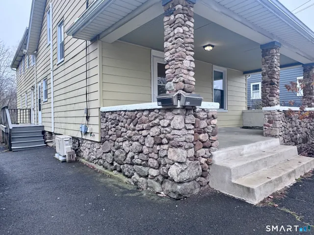 a front view of a house with a tree