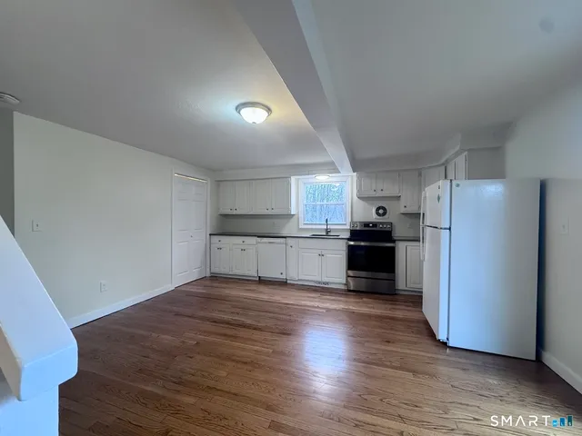 a view of a kitchen with wooden floor and electronic appliances