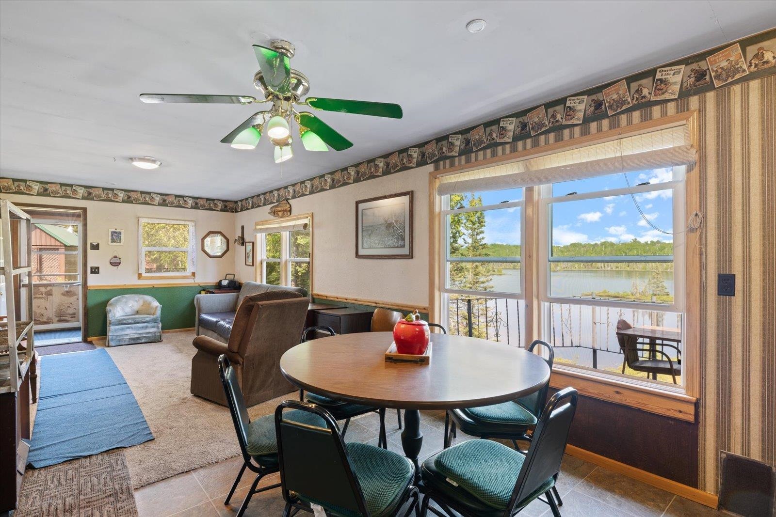 9420 Vollmer Drive Isabella, MN 55607 - Photo 20 of 37 Carpeted dining space featuring a water view, ceiling fan, tile patterned flooring, wallpapered walls, and baseboards