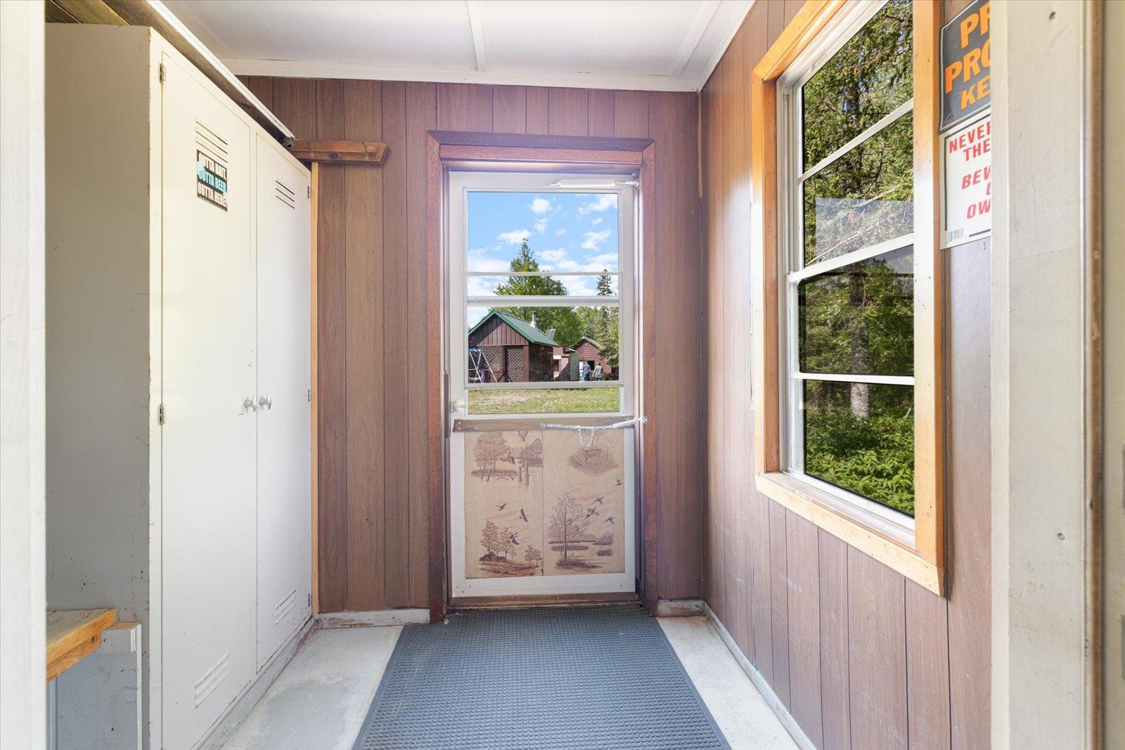 9420 Vollmer Drive Isabella, MN 55607 - Photo 24 of 37 Doorway with wood walls, plenty of natural light, ornamental molding, and baseboards