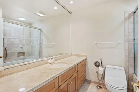 a bathroom with a granite countertop sink toilet and shower