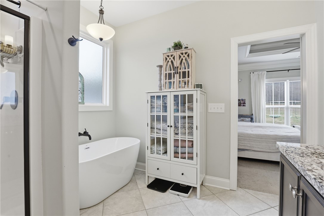127 West Stewart Street Pelzer, SC 29669 - Photo 10 of 23 This serene bathroom offers a spacious soaking tub and an elegant tiled floor.