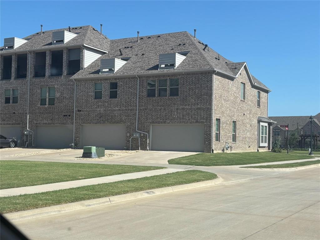 1498 Weston Road Dallas, TX 75234 - Photo 22 of 24 Brick exterior featuring a multi-level roofline, double-pane windows, and an attached two-car garage