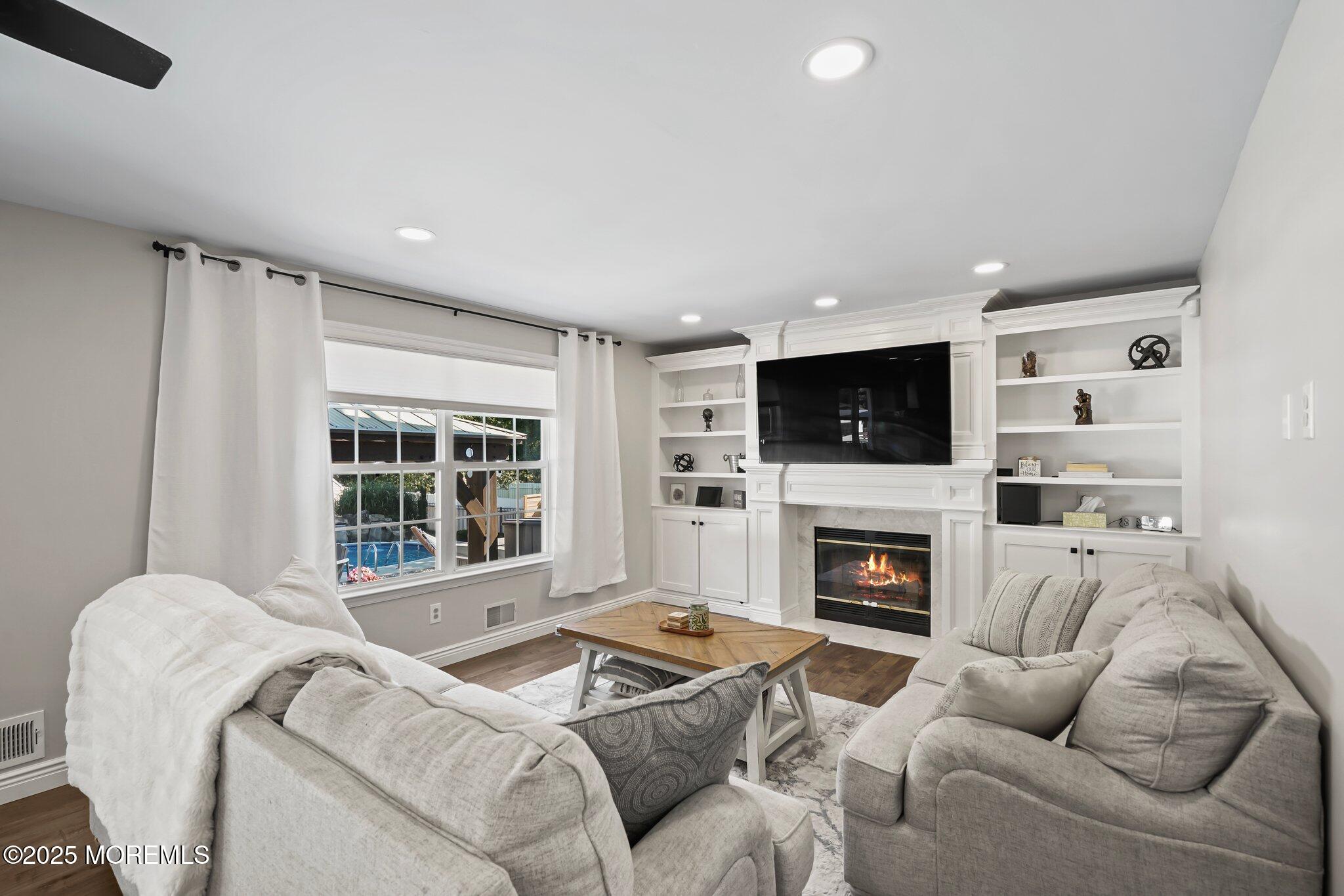 24 Mount Ranier Drive Howell, NJ 07731 - Photo 17 of 53 a living room with furniture a fireplace and a flat screen tv