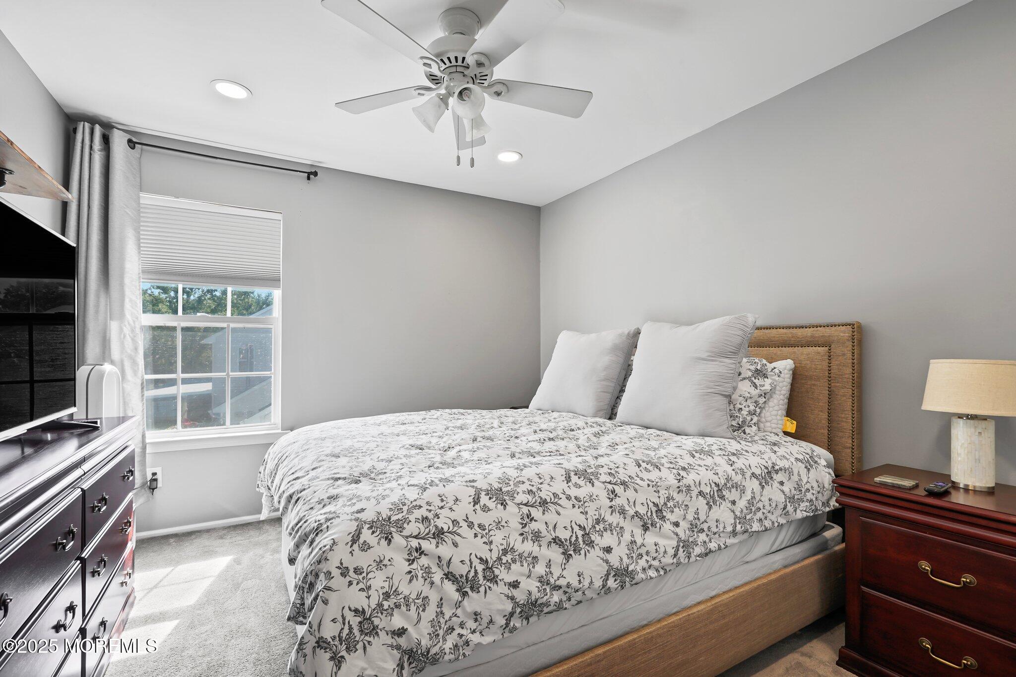 24 Mount Ranier Drive Howell, NJ 07731 - Photo 31 of 53 a bedroom with a large bed and a flat tv screen on dresser