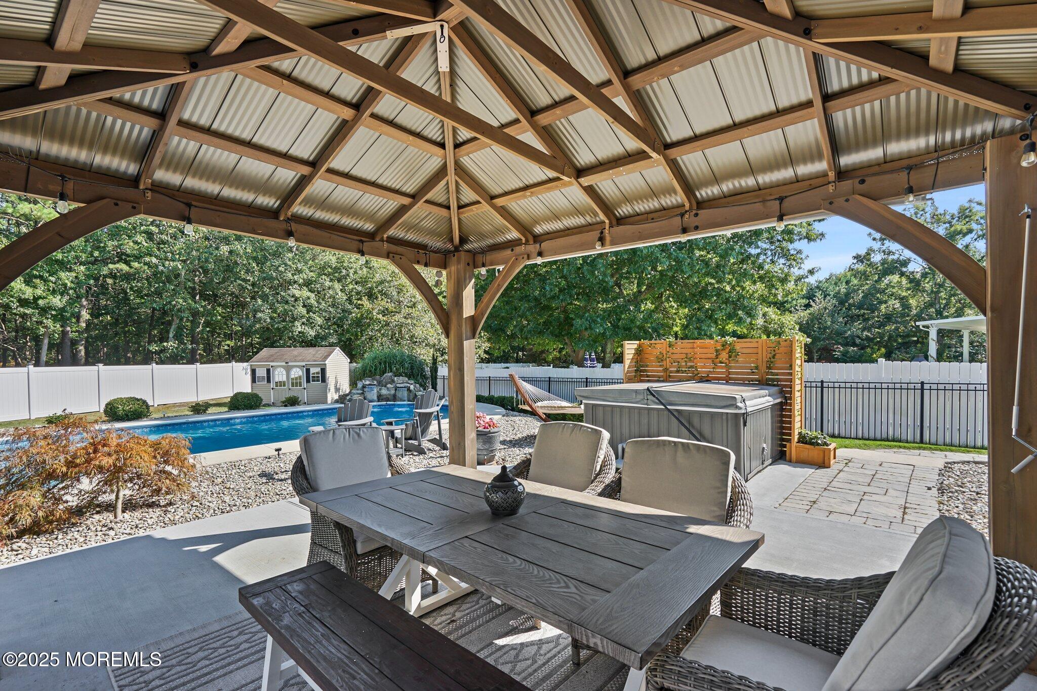 24 Mount Ranier Drive Howell, NJ 07731 - Photo 41 of 53 a view of a patio with table and chairs a barbeque with wooden floor and roof