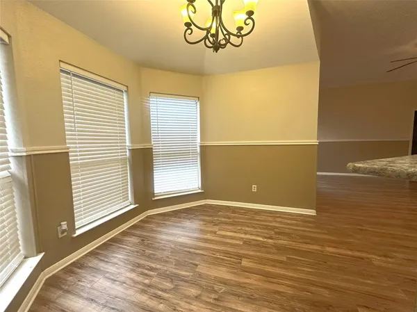a view of a room with wooden floor and a window