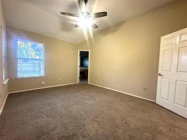 an empty room with windows and fan