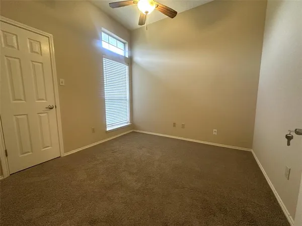 an empty room with closet and chandelier fan