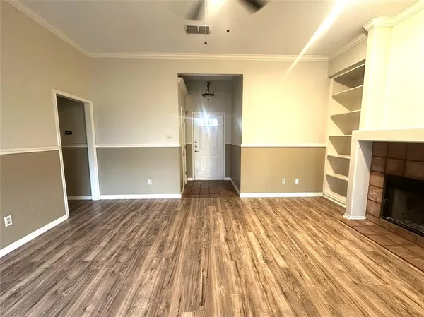 a view of empty room with wooden floor and fireplace