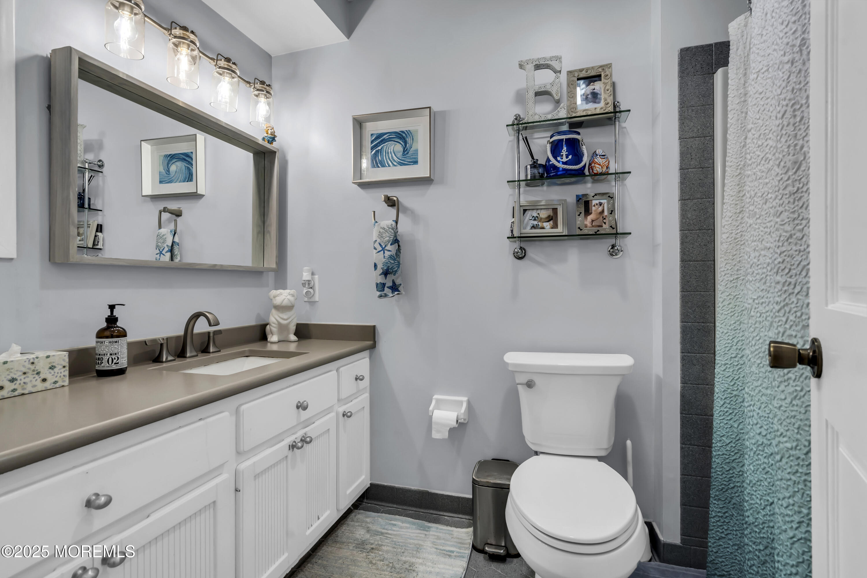 a bathroom with a granite countertop toilet sink and mirror