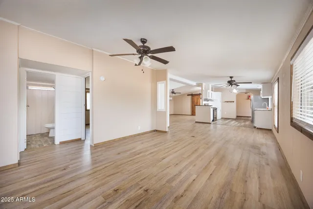 a view of a livingroom with wooden floor and a ceiling fan