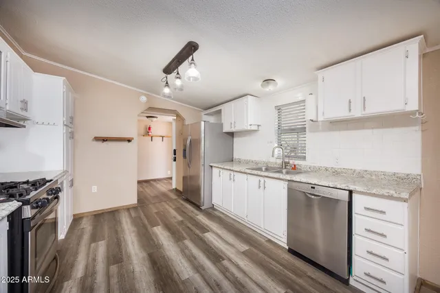 a kitchen with granite countertop white cabinets and white appliances