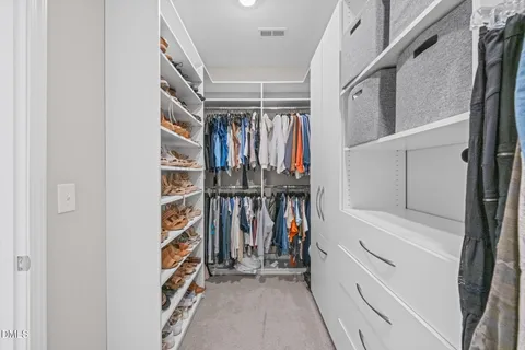 a view of walk in closet with clothes