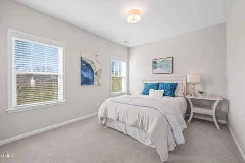 a bedroom with a bed lamp and a window