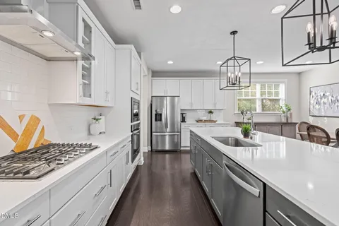 a large kitchen with stainless steel appliances granite countertop a sink stove and refrigerator