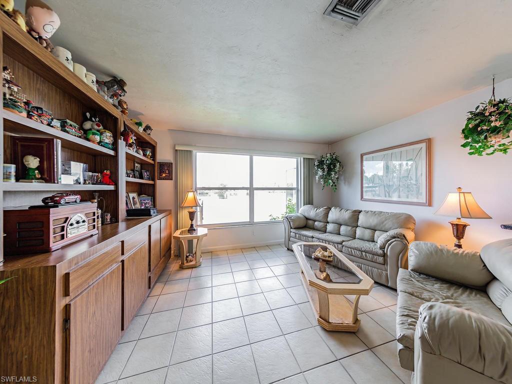 3065 50th Lane Southwest Naples, FL 34116 - Photo 11 of 25 a living room with furniture a flat screen tv and a window