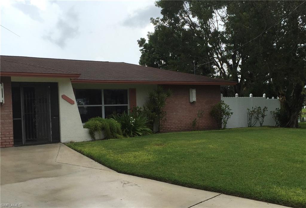 3065 50th Lane Southwest Naples, FL 34116 - Photo 17 of 25 a front view of a house with a yard and garage