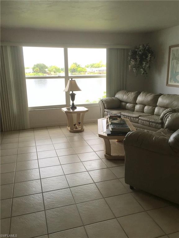 3065 50th Lane Southwest Naples, FL 34116 - Photo 24 of 25 a living room with furniture and a floor to ceiling window