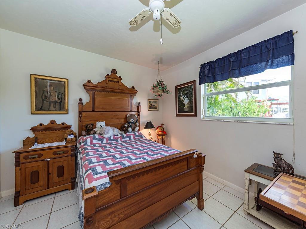 3065 50th Lane Southwest Naples, FL 34116 - Photo 10 of 25 a bed room with a bed and a chandelier