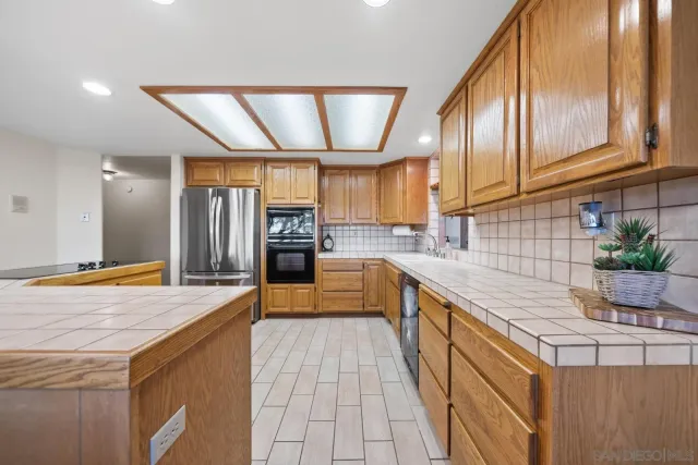 a kitchen with stainless steel appliances granite countertop a sink a stove and cabinets