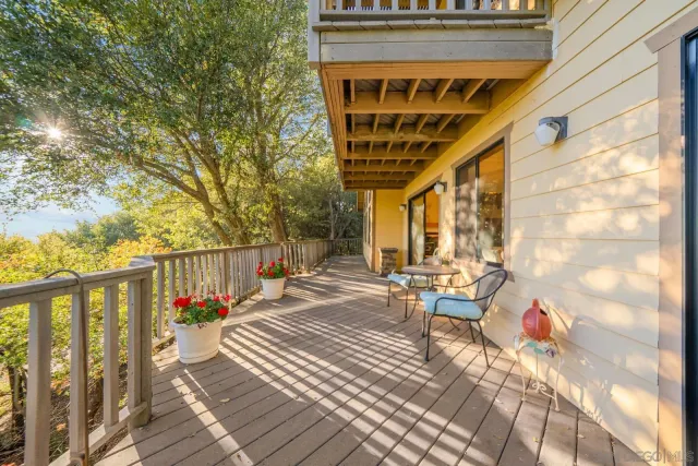 a view of a balcony with chairs and wooden floor