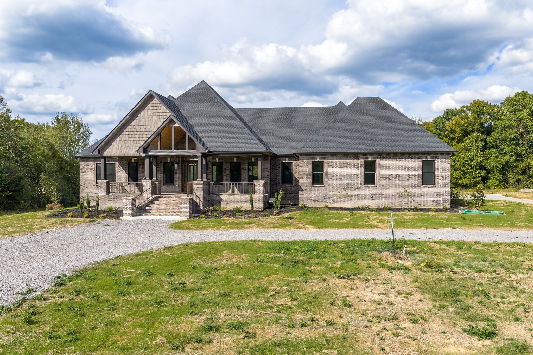 a front view of a house with swimming pool and porch with furniture