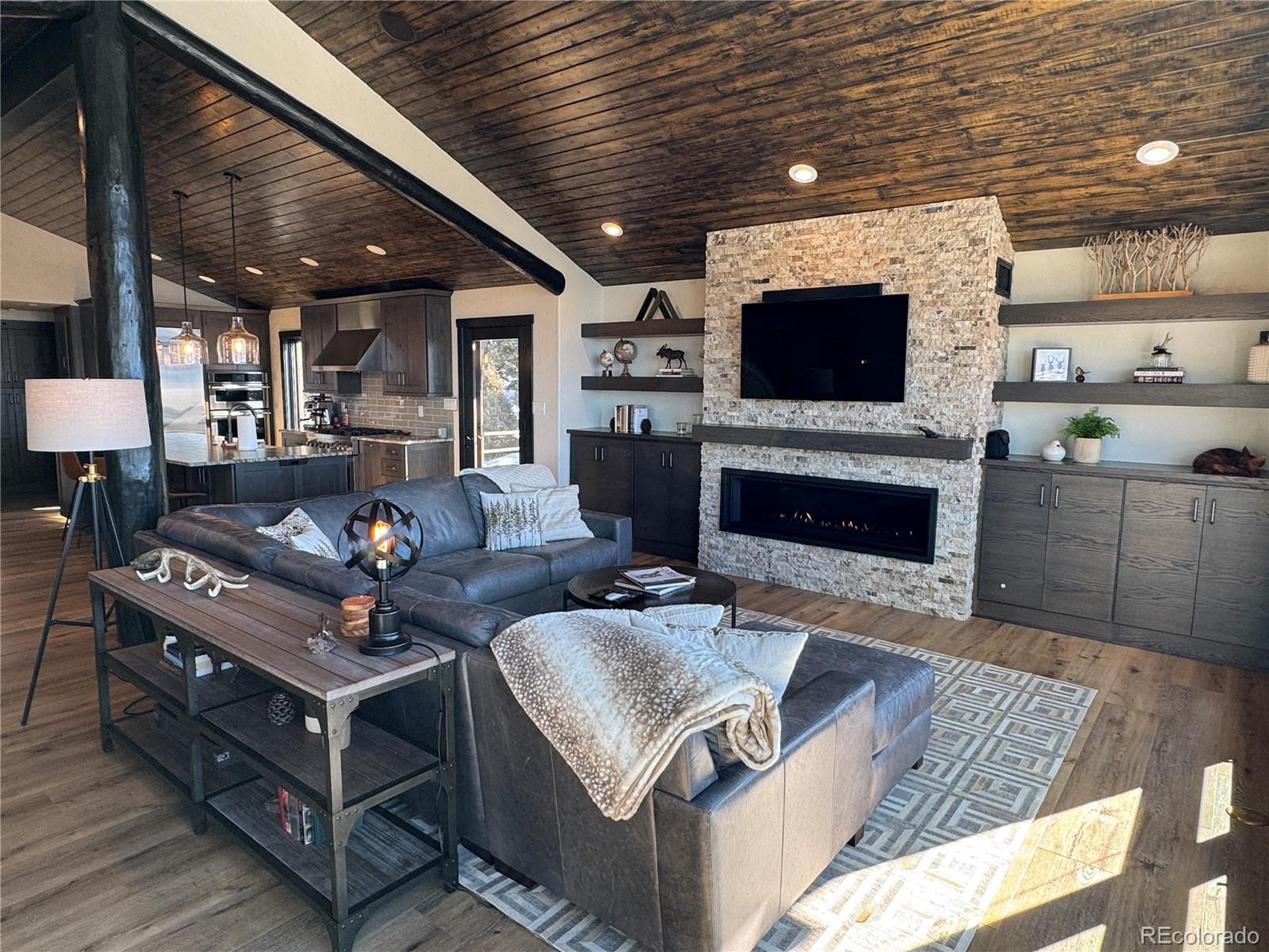 680 Ridge Road Westcliffe, CO 81252 - Photo 19 of 46 a living room with furniture a flat screen tv and a fireplace
