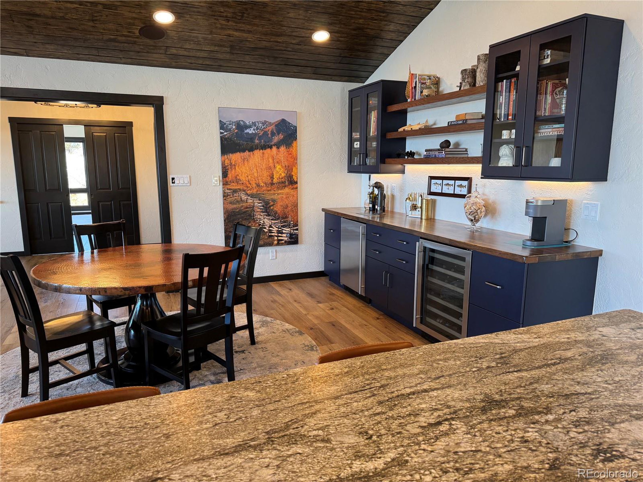 680 Ridge Road Westcliffe, CO 81252 - Photo 20 of 46 a kitchen with stainless steel appliances granite countertop a sink wooden cabinets dining table and chairs