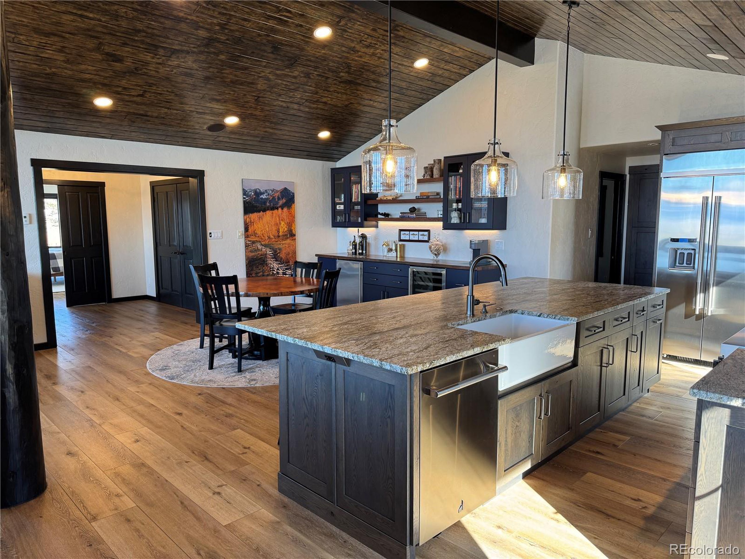 680 Ridge Road Westcliffe, CO 81252 - Photo 22 of 46 an open kitchen with kitchen island a sink stove and wooden floor