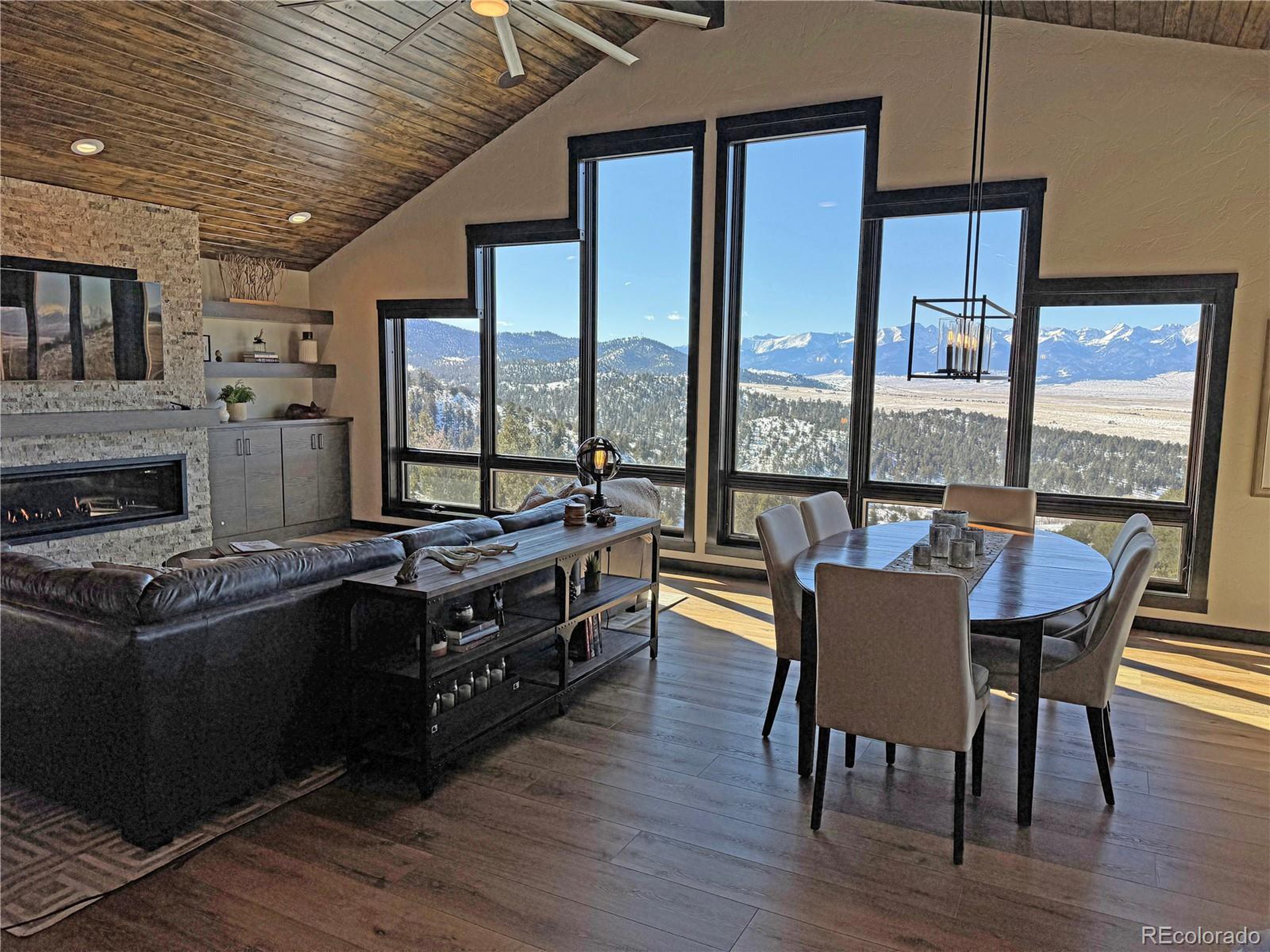 680 Ridge Road Westcliffe, CO 81252 - Photo 24 of 46 a view of a dining room with furniture large windows and wooden floor