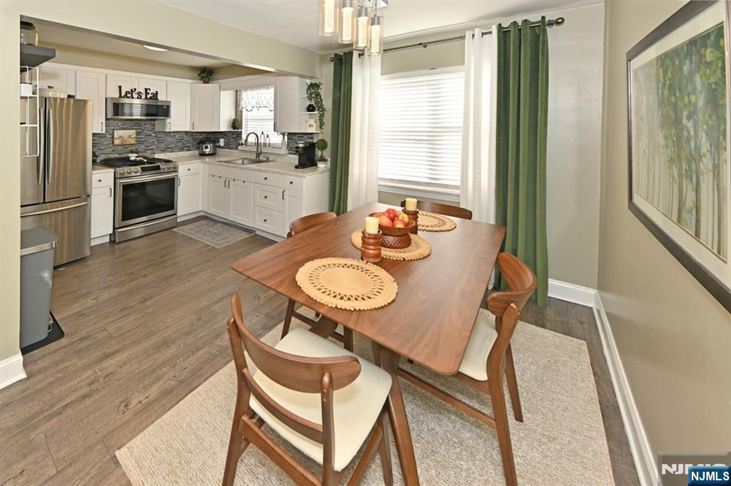 483 Colonial Terrace, Unit 9 Hackensack, NJ 07601 - Photo 6 of 25 a kitchen with stainless steel appliances kitchen island granite countertop a refrigerator a stove and a dining table with wooden floor