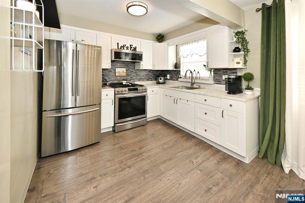 483 Colonial Terrace, Unit 9 Hackensack, NJ 07601 - Photo 9 of 25 a kitchen with stainless steel appliances a refrigerator sink and microwave