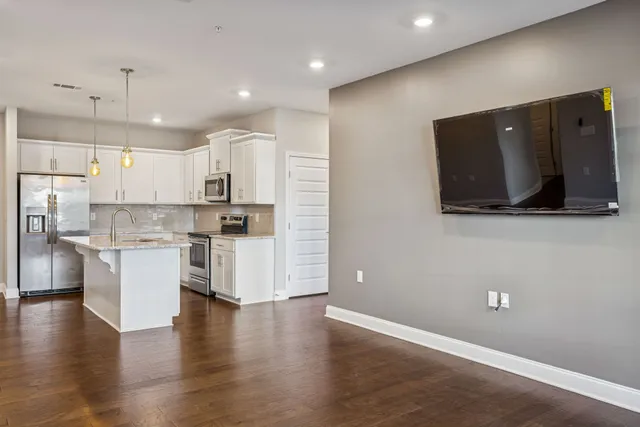 a kitchen with a refrigerator and a stove top oven
