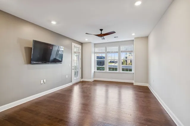 a view of a livingroom with wooden floor and a flat screen tv